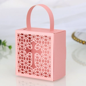 Detail of pink laser-cut cross hollow candy box with pearl paper and ribbon handle