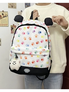 Detail of white paw-print backpack with decorative ears and plush charm accessory