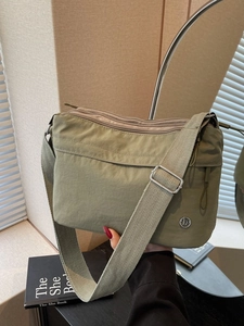 Olive green waterproof nylon tote bag with wide canvas strap and multi-pocket design