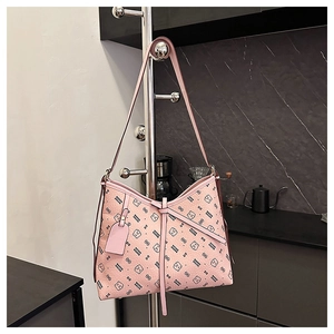 Detailed close-up of pink hobo bag with teddy bear pattern and decorative bow