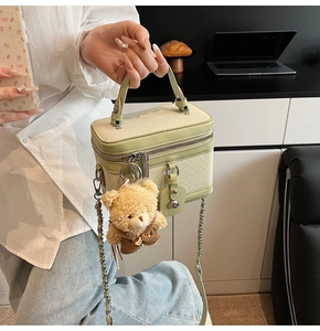 Détail du sac bowling tressé vert clair avec un charmant petit ours en peluche