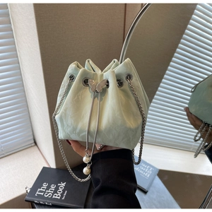 Détail du sac seau plissé vert clair avec papillon argenté et breloques en perles