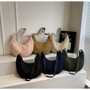 Detail von minimalistischen Nylon-Halbmondtaschen in verschiedenen Farben mit Fronttaschen