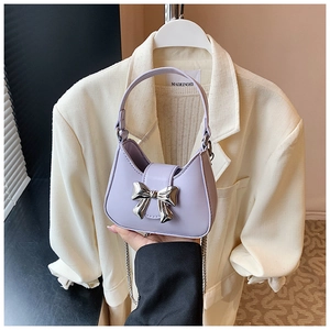 Détail du mini sac lavande avec nœud argenté et bandoulière en chaîne métal