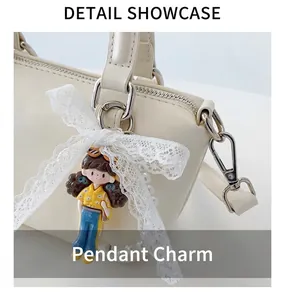 Detail of off-white handbag with cute doll pendant, lace bow and pearl decoration