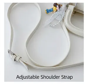 Detail showing adjustable shoulder strap with silver buckle and pearl chain on white bag