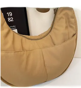 Detailansicht der khakifarbenen Halbmond-Segeltuchtasche mit weicher Textur und Seitentasche
