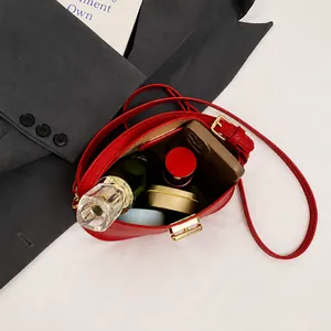 Details der roten Leder-Handtasche mit Innenraum für Alltagsutensilien und Goldverschluss