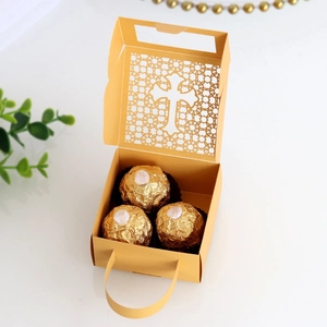Detail of golden hollow cross gift box with laser cut design and portable handle