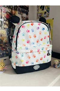 Detail of white backpack with colorful claw prints and 3D black cat ear decorations