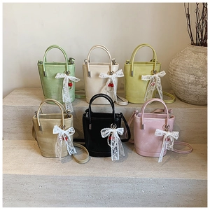 Collection de sacs seaux en six couleurs avec nœuds en dentelle sur des marches en pierre