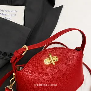 Nahaufnahme der roten Lederhandtasche mit Kieselmaserung und goldenem Drehverschluss