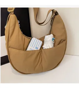 Detail der khakifarbenen Nylon-Halbmondtasche mit zwei Vordertaschen und viel Stauraum