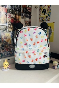 Detail of white backpack featuring colorful animal paw prints and cute black ear accents