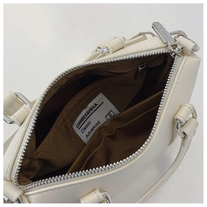 Detail view of the spacious inner compartment with brown lining and a zipper pocket