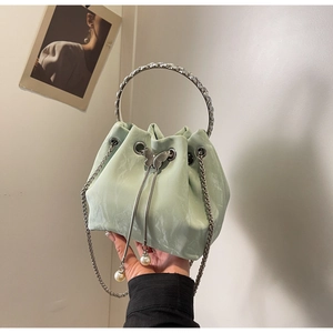 Gros plan du sac seau vert menthe avec poignée strass et cordon de serrage perlé