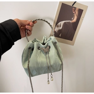 Détail de ce sac seau vert menthe avec poignée argentée et pendentif perle
