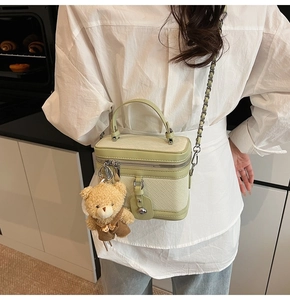 Gros plan sur le sac à main tissé vert pistache avec charmant petit ours en peluche