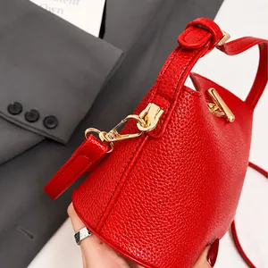 Makroaufnahme der roten Handtasche mit Litschi-Leder und goldenen Metallverschlüssen