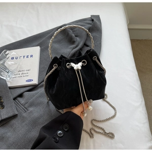 Détail du sac seau en velours noir avec fermoir papillon argenté et perles de cordon
