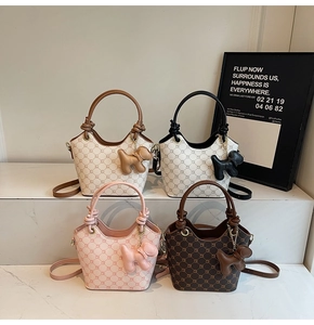 Détail de sacs seaux à monogramme en plusieurs couleurs avec pendentifs chien sur marbre