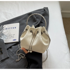 Détail du sac seau blanc crème avec poignée anneau argentée et cordon papillon
