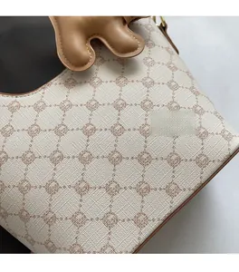Gros plan d'un sac seau en cuir Saffiano avec imprimé géométrique et breloque