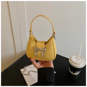 Détail d'un mini sac jaune en cuir avec une boucle de nœud papillon en métal argenté