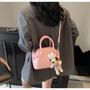 Bolso rosa de piel con textura de grano y colgante de perrito con correa ajustable