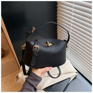 Details der schwarzen Beuteltasche aus genarbtem Leder mit goldenem Drehverschluss