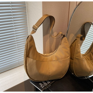 Detail der khakifarbene Halbmond-Tasche mit breitem Gurt und vorderen Taschen