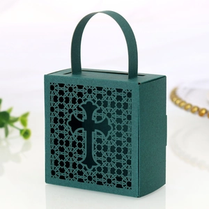 Detail of dark green wedding favor box featuring intricate laser-cut cross design