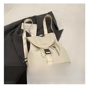 Dettaglio dello zaino chic in nylon bianco crema con fibbia nera e scritta sul davanti