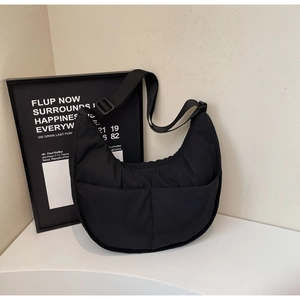 Detail der schwarzen Halbmond-Tasche mit doppelten Vordertaschen und verstellbarem Gurt