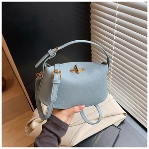 Nahaufnahme der hellblauen Handtasche mit Litschimuster und elegantem goldfarbenem Drehverschluss