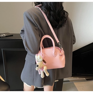 Detalle de textura de bolso rosa con grano de lichi y colgante de reno suave
