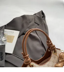 Détail du sac seau en toile avec poignée en cuir, zip doré et pendentif en forme de cœur