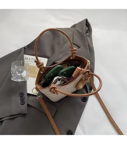 Vue de dessus du sac seau imprimé spacieux contenant téléphones et rouge à lèvres