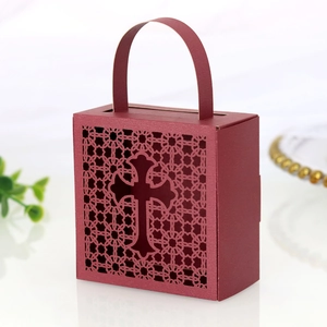 Macro detail of wine red laser-cut candy box featuring hollow cross design and handle