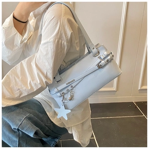 Detail of light blue PU leather handbag with white star and silver heart charm pendants