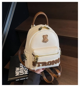 Détail d'un mini sac à dos en PU crème avec broderie d'ours 3D et fermetures dorées