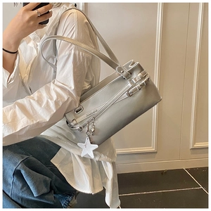 Detailed view of silver matte shoulder bag with buckle straps and star charm accessory