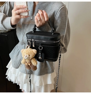 Détail du sac boîte noir tissé avec chaîne argentée et pendentif ours en peluche