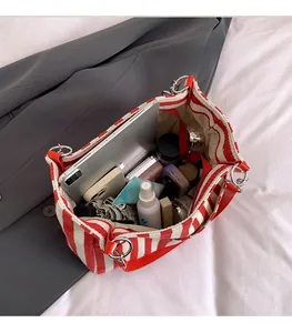 Intérieur spacieux du cabas en toile à rayures rouges et blanches avec tablette et objets