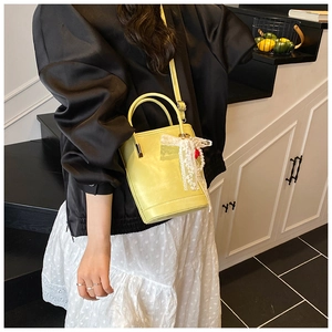 Sac seau vert citron avec nœud en dentelle et perles dans un décor mode moderne