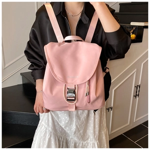 Dettaglio dello zaino in nylon rosa con chiusura a patta e fibbia in plastica nera