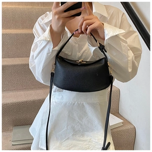 Spiegelselfie der kleinen schwarzen Umhängetasche aus Leder mit goldenen Metallelementen