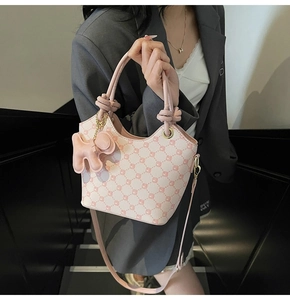 Détail du sac cabas rose avec texture matelassée florale et pendentif chiot doré