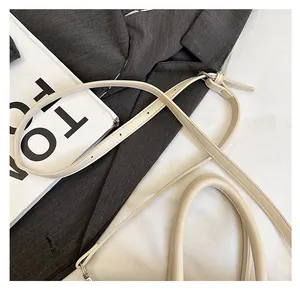 Detail of adjustable beige strap and silver buckle on a minimalist satchel bag