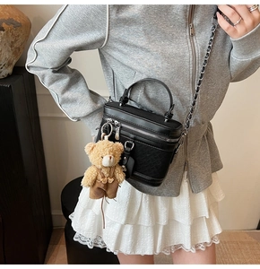 Détail du sac boîte noir tissé avec chaîne argentée et charmant pendentif en ours